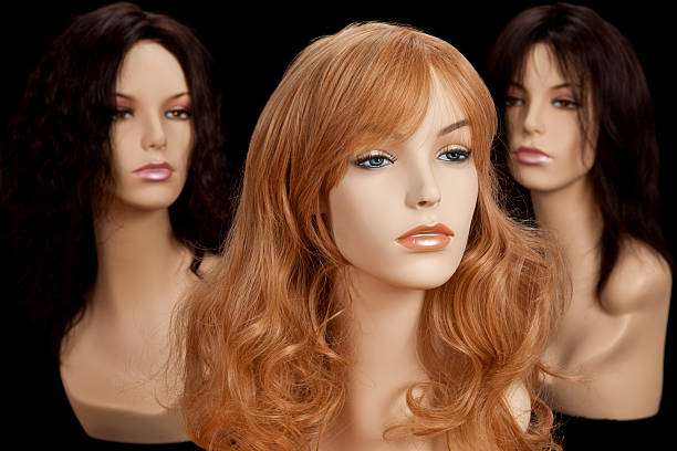 Three mannequin heads with different hair colors on a black background